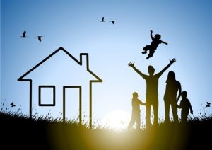 Happy family and house at sunset in a meadow